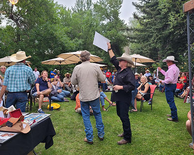 Robert Taylor and John Bishop display items for bidding during the auction in the Occidental Beer Garden.